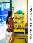 Unrecognizable young Latin woman tourist wearing casual warm jacket and eyeglasses standing in Blue House of Frida Kahlo Museum in Mexico City and looking at exhibition