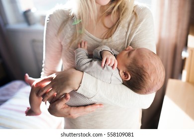 Unrecognizable Young Mother Holding Her Baby Son In Her Arms