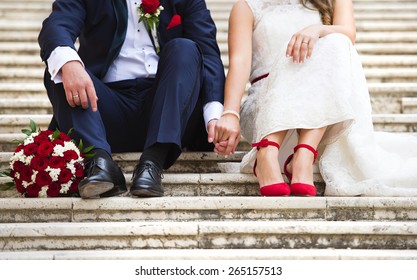 Unrecognizable young wedding couple holding hands as they enjoy romantic moments outside on the stairs - Powered by Shutterstock