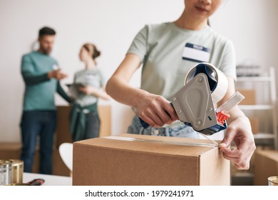 Unrecognizable young woman packing boxes at charity and donations event, copy space