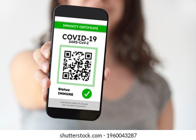 Unrecognizable young woman showing on her smartphone screen a certificate of immunity against Covid19. Concept of travel and health protocols during the corona virus pandemic.