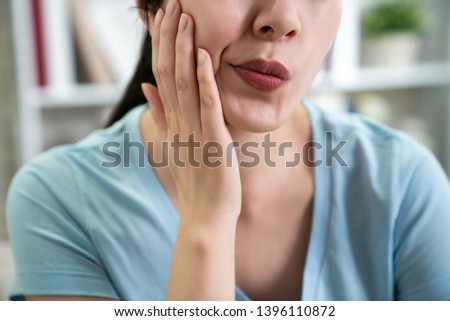unrecognized asian woman feeling tooth pain hands touching face cheek unhealthy problem at home. female suffering from strong teeth pain toothache. Dental health and care medical lifestyle concept