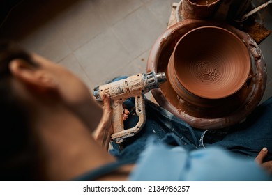 Unrecognized ceramicist holding blowtorch in hand in pottery workshop - Powered by Shutterstock