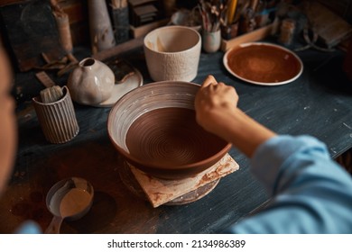 Unrecognized craft woman finishing process of manufacturing ceramic bowl in pottery workshop - Powered by Shutterstock