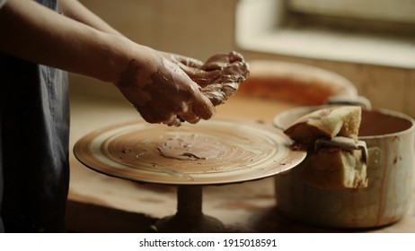 Unrecognized female master sculpting clay in workshop. Closeup woman hands modeling clay piece in studio. Unknown artist getting ready to make product in pottery. - Powered by Shutterstock