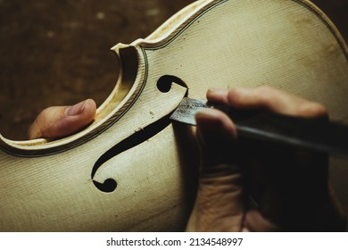 Unrecognized luthier creating a violin and using tools