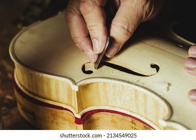 Unrecognized luthier creating a violin and using tools - Powered by Shutterstock