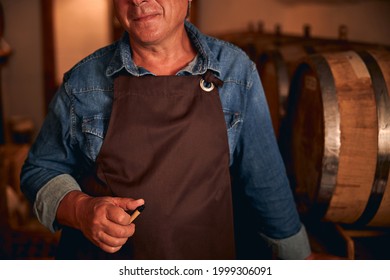 Unrecognized Male Sommelier In Apron And Denim Shirt