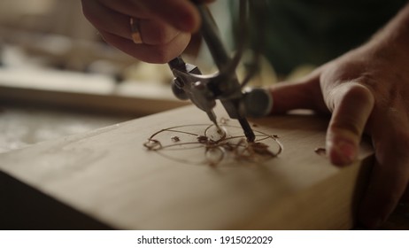 Unrecognized man carving ornament with tool in carpentry workshop. Closeup unknown carpenter making decor in studio. Wood worker sweeping out sawdust indoors in slow motion.