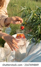 Unrecognized woman making a refreshing drink from strawberries at a picnic. - Shutterstock ID 2167694849
