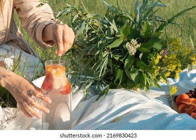 Unrecognized woman making a refreshing drink from strawberries at a picnic. - Shutterstock ID 2169830423