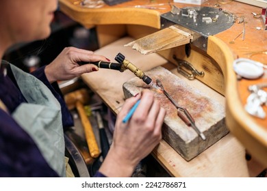 Unrecognized woman using blowtorch in jewelry workshop. - Powered by Shutterstock