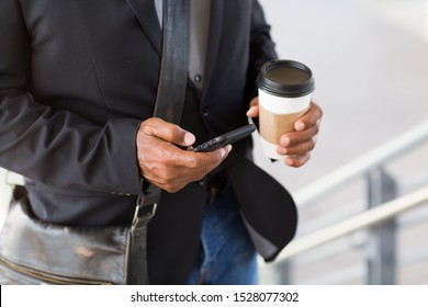 Unrecongnizable African American Businessman Drinking Coffee And Texting.