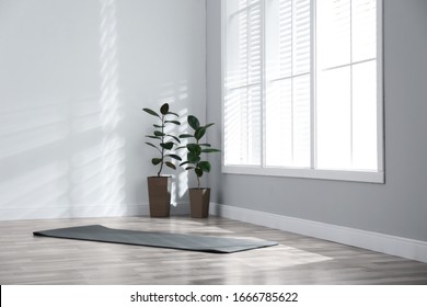 Unrolled Grey Yoga Mat On Floor In Room