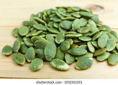 Unsalted Green Pumpkin Seed On Wooden Board.