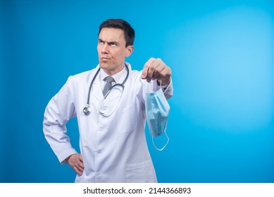 Unsatisfied physician giving medical mask in studio