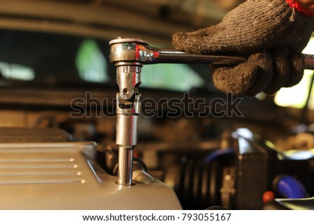 Unscrew wrench car.Worker and auto repair equipment.Auto mechanic repair the car engine