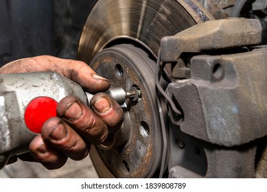 Unscrewing The Old Brake Disc From The Car With A Pneumatic Screwdriver.