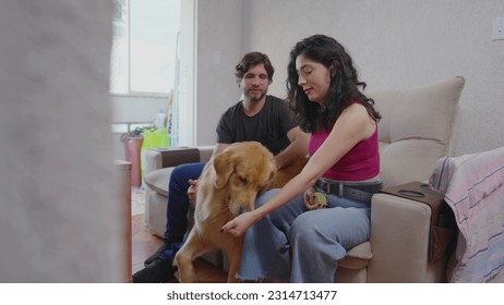 Unscripted Joy_ Woman and Partner Bond with Golden Retriever over Game of Fetch at Home