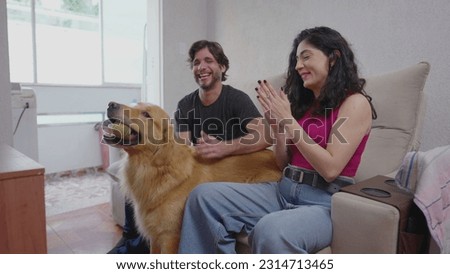 Unscripted Joy_ Woman and Partner Bond with Golden Retriever over Game of Fetch at Home