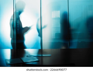 The unseen work is often the most important. Cropped shot of an unrecognizable businessmans silhouette against a glass wall in his office.