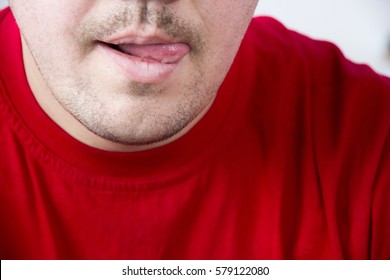 Unshaven Man In Red Shirt Tongue Licking Lips