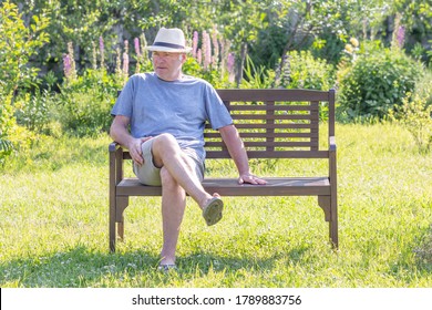 An unshaven man sits on a park bench - Powered by Shutterstock