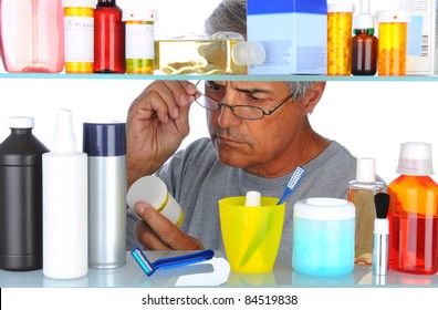 Unshaven Middle Aged Man Reading A Prescription Label In Front Of His Bathroom Medicine Cabinet. Horizontal Format Isolated On White.