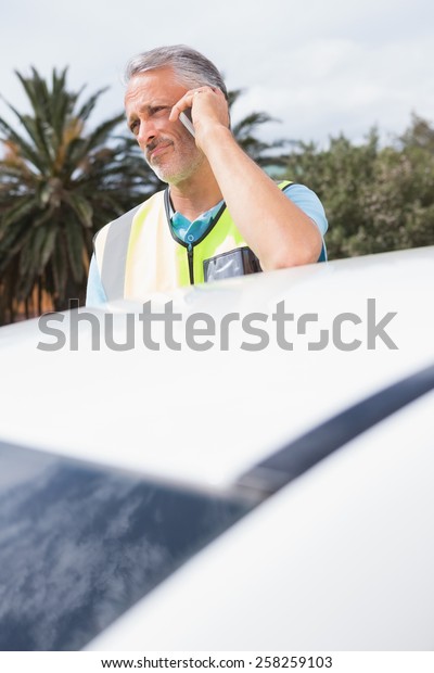 Unsmiling man calling for assistance after breaking\
down on the road
