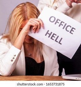 Unstable Female Boss Aggressive Gesturing And Screaming At Her Employee. Young Employee Holding Sign Office Hell. 