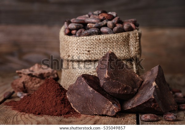 unsweetened baking block chocolate, Cocoa\
powder and cocoa beans on old wooden\
background
