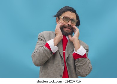 An untidy man, wearing broken glasses, expressing horror, over light blue background