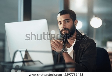 Until the task is done, Im staying right here. a young businessman using a computer during a late night in a modern office.