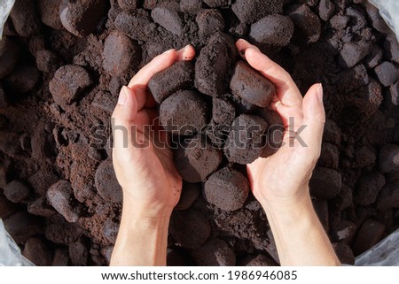 Unused coffee grounds with male hand.