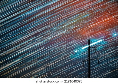 Unusual Amazing Effects In Sky. Bright Night Starry Sky Background. Trails Of Stars Rotate Above Power Line. Large Exposure. Imagination, Fantasy, Illusion, Dream View. Flight Of Fancy.