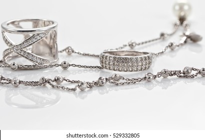 Unusual beautiful silver chain and a silver ring with gems on the reflecting surface - Powered by Shutterstock