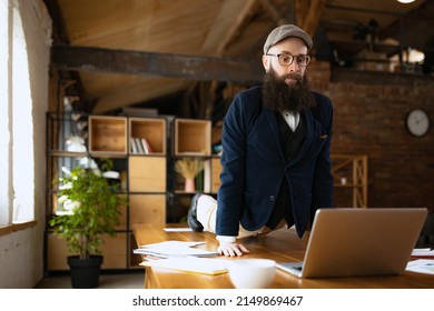 Unusual business process. Young bearded man, office clerk having fun, doing yoga on wooden table in modern office at work time with gadgets. Concept of business, healthy lifestyle, sport, hobby - Shutterstock ID 2149869467
