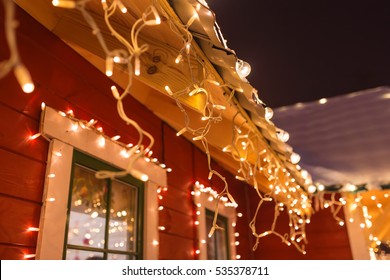 unusual christmas wreath on window. luxury decorated store front with garland lights in european city street at winter seasonal holidays