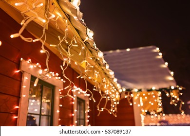 Unusual Christmas Wreath On Window. Luxury Decorated Store Front With Garland Lights In European City Street At Winter Seasonal Holidays