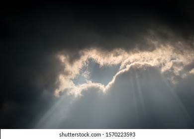 An Unusual Cloud Formation With Dark Storm Clouds Meeting Light, A Bright Silver Lining As The Sun Shines Through A Gap