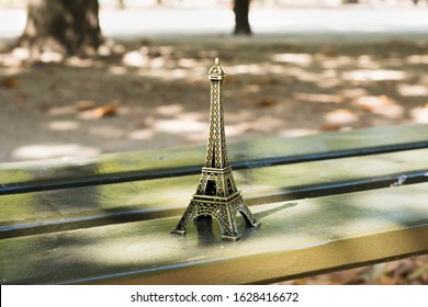 Unusual composition with small Eiffel Tower on bench