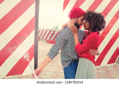 Unusual date. Calm dreamy young man gently hugging his beloved woman while standing with smoke flare in his hand - Powered by Shutterstock