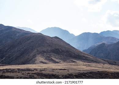 Unusual mountain landscape on a dull autumn day. Remote foothill areas in northern China. Dry grassy fields and hills. Natural background. Exploration of new places, travel to remote locations. - Shutterstock ID 2171901777
