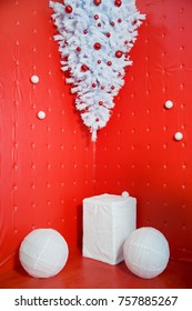 Unusual New Year decor - white spruce on a red background, upside down