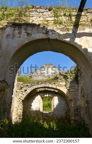 An unusual picturesque arched through passage into the rooms of an old ruined church. Copy space. Selective focus.