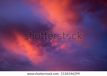 Unusual pink-purple mammatus clouds at sunset. Blurred image for backgrounds.