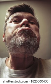 Unusual Portrait Of An Adult Bearded Man. A 44 Year Old Man With A Beard Grimaces In Front Of The Camera. Close-up. Selective Focus.