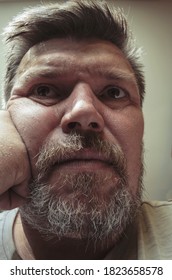 Unusual Portrait Of An Adult Unshaven Man. A 44 Year Old Man With A Beard Sits Thoughtfully In Front Of The Camera. Close-up. Selective Focus.