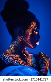 unusual shoot of fashion model woman in neon light. portrait of young beautiful model girl with fluorescent makeup. Body art design in UV, painted face, colorful make up on skin