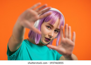 Unusual Trendy Woman With Dyed Pink Hair Listening Music, Dancing In Headphones On Orange Background. Color Block. Fashionista Teen Girl